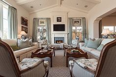 a living room filled with lots of furniture next to a fire place in a house