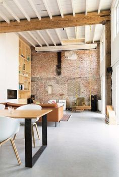 a living room filled with furniture and a brick wall