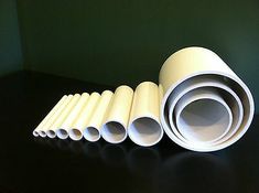 several rolls of white paper sitting on top of a black table next to each other