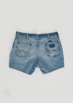 "Vintage 1970s Wrangler cut off shorts Medium light wash blue jeans with embroidered W back pockets and black label Wrangler 100% cotton Great vintage condition - burnout with perfectly worn in with stains (see photos) Cut off jeans have with sewn hem M e a s u r e m e n t s: Size: 36 30 - actual W35 Waist: 17 1/2\" Hips: 22\" Total length: 14 1/2\" Material: 100% cotton Inseam: 5\" Rise: 12\" Label: Wrangler - style 82612NV made in USA +All Measurements are taking while garment is lying flat+ i Vintage Washed Cutoff Bottoms, Vintage Washed Cutoff Jean Shorts, Vintage Washed Faded Jean Shorts, Vintage Faded Washed Jean Shorts, Faded Vintage Washed Jean Shorts, Vintage Medium Wash Jean Shorts With Frayed Hem, Vintage Washed Jean Shorts, Faded Vintage Cotton Jean Shorts, Vintage Distressed Cutoff Jean Shorts