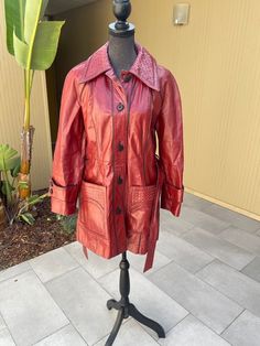 70s oxblood leather long belted vintage jacket with woven leather collar and pocket details  Made in Taiwan  Good condition, leather is in good shape and has been well cared for over the years, one of the pockets is coming apart at the top but this is an easy fix or wear it as is, you can't tell unless its pointed out to you Labeled a size 12 Measures (laying flat): 19" pit to pit, 16" pit to end of sleeve, 24" shoulder to end of sleeve and 32.5" long Black piping accents, tabbed cuff details, p Vintage Long Leather Jacket For Fall, Vintage Long Sleeve Belted Outerwear, Red Vintage Leather Jacket With Long Sleeves, Vintage Red Leather Outerwear, Vintage Collared Leather Jacket For Fall, Vintage Burgundy Outerwear For Fall, Oxblood Leather, Cuff Detail, San Rafael