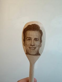 a wooden spoon with a drawing of a man's face on it