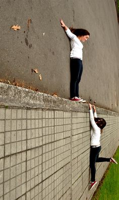 two women standing on the side of a wall