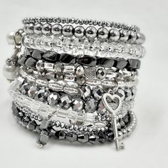 This Stacked Silver Bracelet Is Made On Memory Wire To Wrap Around Your Wrist 11 Times. It Is Strung With Crystals, Czech Beads, Glass Beads, Metal Beads, Hematite, And Finished Perfectly With Multiple Handmade Crystal And Pearl Drops On Each End And 2 Silver Charms: A Key And A Lock. It’s A Perfect Layered Look Filled With Crystals And Bling. Adjustable Silver Stackable Bracelets, Silver Stackable Charm Bracelet, Adjustable Stackable Silver Bracelets, Stackable Silver Charm Bracelet, Silver Stackable Stretch Bracelet As Gift, Silver Stackable Stretch Bracelet For Parties, Silver Stackable Crystal Bangle Bracelet, Silver Stackable Metal Beaded Bracelets, Silver Stackable Bangle Charm Bracelet