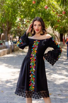 This Beautiful Dress boasts a Traditional Mexican floral design combined with a modern style dress. The embroidered bodice combined with the bell sleeves and lace make it fun and flirty. It's made out of fine Mexican cotton and has elastic around the top for an adjustable fit. This dress is handmade and embroidered by Mexican Artisans in Guanajuato, Mexico. Purchase the Men's Matching Guayabera here: https://www.etsy.com/es/listing/1184172577/guayabera-mexicana-bordado-floral-camisa?ref=listings Mexican Dresses Traditional Embroidery, Blue Mexican Dress, Spanish Style Dress Classy, Mexican Jacket Outfit, Mexican Black Dress, Mens Mexican Outfit, Black Mexican Dress, Elegant Mexican Dresses For Women, Modern Mexican Dress