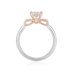 a white and rose gold ring with a bow on the side, set in two tone gold