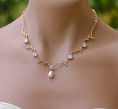 a woman wearing a necklace with pearls on it