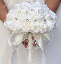 the bride's bouquet is made up of white roses, pearls and swaroons