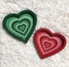 two heart shaped trays sitting on top of a white blanket