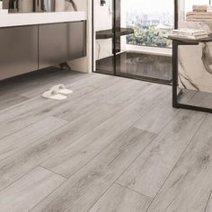 a bathroom with grey wood flooring and white walls