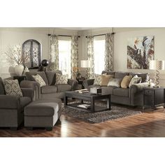 a living room filled with lots of furniture and decor on top of a hard wood floor