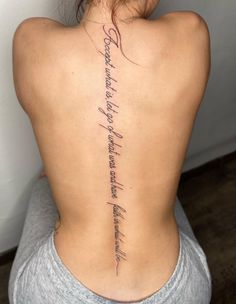 the back of a woman's neck with words written on her upper and lower back