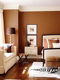 a living room with brown walls and zebra print rugs on the hardwood flooring