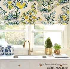 a kitchen window with yellow and blue flowers on the valance, next to a sink