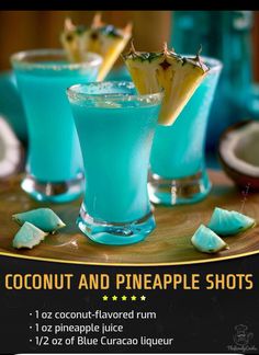 two glasses filled with blue liquid and topped with pineapple