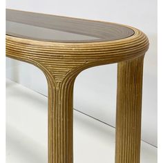 a table that is made out of wood and has glass on the top, along with an oval shaped base