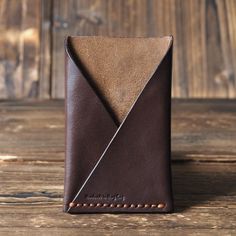 a brown leather wallet sitting on top of a wooden table