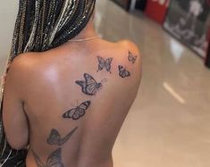 the back of a woman's shoulder with butterflies on it