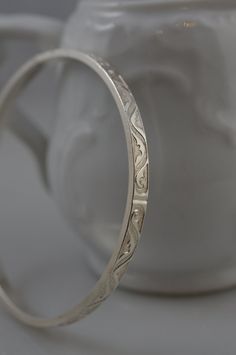 Now offering FREE SHIPPING on all US orders and 10% off all orders of $100 or more! Items ship in 1-3 days The simple scroll pattern on this sterling silver bangle makes it right on trend. It's the perfect go to piece for effortless style. I hand formed, hammered, and polished this piece then tumbled it (for durability) to make a bracelet that will stand the test of time. Wear it alone or stack it! Bracelet is about 4mm wide, 2mm thick and is available in sizes small, medium and large. Looks gre Luxury Silver Temple Jewelry Bangle, Adjustable Round Etched Bracelets, Adjustable Etched Round Bracelets, Adjustable Etched Bracelets, Adjustable Etched Round Bangle, Adjustable Etched Bangle, Etched Sterling Silver Bracelet As Gift, Etched Sterling Silver Bracelet Gift, Etched Sterling Silver Round Bracelets