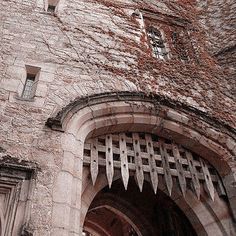 an old stone building with arched doorways and ivy growing up the side of it