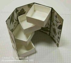 an open box with three compartments on the inside and one in the middle, sitting on top of a table