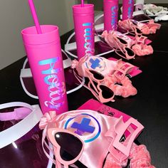 pink items are lined up on a table with sunglasses and other accessories around them,