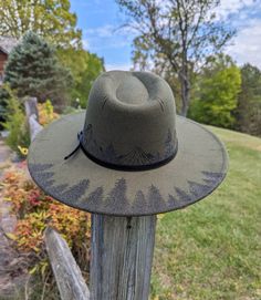 This hand burnt olive green wide brim fedora makes a perfect addition to any nature lover's wardrobe. I burnt pine trees on the back brim of the hat. Around the entire crown of the hat I intricately burned and shaded mountains and pine trees by hand with a pyrography machine. The design is original and completely free-handed. For a finishing touch, I added faux stitch marks on the crown and brim of the hat. The hat has a faux leather black belt hat band. Hat Materials: polyester/cotton Hat circu Burned Hat Mountains, Country Fedora Hats For Outdoor Activities, Country Style Fedora Hat For Outdoor Activities, Country Style Fedora For Outdoor Activities, Outdoor Fedora Felt Hat, Outdoor Felt Fedora Hat, Country Style Hat With Flat Crown For Outdoor, Country Style Flat Crown Hat For Outdoor, Rustic Wide Brim Hat Bands For Outdoors