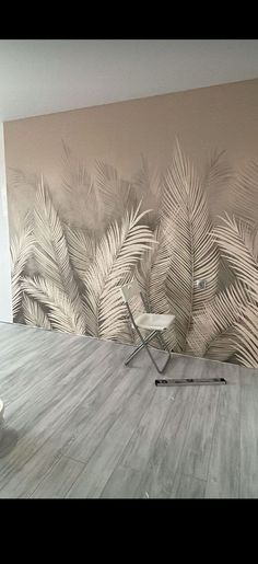 an empty room with a chair and palm tree wall mural on the wall behind it