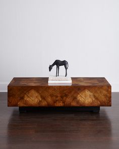 a wooden table with a horse figurine on top and a book in the middle