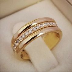 a gold ring with two rows of diamonds in it