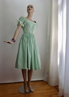 "Super Cute, 1950's ALL COTTON Mint Green Dress with a boxy square neckline & puffy lace sleeves. The neckline & lace sleeves gives this dress a mix between a baby doll dress and a German Fraulein maid dress.. The bodice is fitted with a nipped waist and series of cloth covered buttons up the front with a metal zipper down the back. The pleated skirt is full, and would flare out more with a petticoat. This comes with the original matching cloth covered belt. This dress is hand washable, Fitted Retro Vintage Dress With Square Neck, Vintage Dress With Square Neck, Square Neck Retro Vintage Dress, Retro Square Neck Vintage Dress, Vintage Formal Dress With Square Neck, Skirt Puffy, Sleeve Variations, Mint Green Dress, Full Skirt Dress