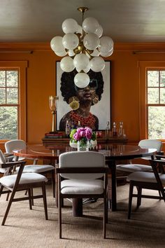 the dining room table is surrounded by white chairs and an art work on the wall