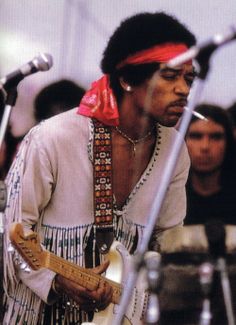 a man with a red bandanna on his head playing guitar