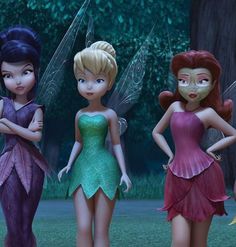 four fairy - like girls standing next to each other in front of some trees and grass