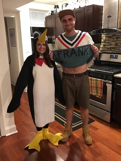 a man and woman in costumes standing next to each other holding a sign that says frank