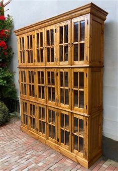 a large wooden cabinet sitting on top of a brick floor