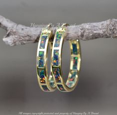 "Gorgeous new earrings made using gold and created opal gemstones. The opal is black with rainbow fire. The opals are inlaid into the gold plated hoops. Hoops have a latch back closure, for easy on and off.  Earrings feature opals along the outer front of each hoop. Earrings measure 3/4\" long. Please see last image for an example of them being modeled to help gauge size (shown in white). * Nickel and lead free ** See all my colors/sizes here: https://www.etsy.com/shop/hangingbyathread1/?etsrc=sdt&search_query=opal+inlay+hoop" Gold Hoop Opal Jewelry, Gold Opal Small Hoop Jewelry, Gold Opal Hoop Jewelry, Small Gold Opal Hoop Jewelry, Gold Opal Small Hoop Earrings, Small Gold Hoop Earrings With Opal, Gold Small Hoop Earrings, Rainbow Fire, Black Rainbow