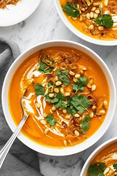 three bowls filled with soup and garnished with cilantro