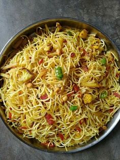 a pan filled with noodles and vegetables on top of a table