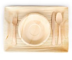 a bamboo place setting with utensils and spoons on the tray, isolated against a white background