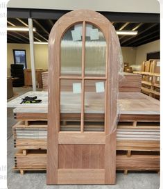 an open wooden door sitting on top of pallets in a room filled with furniture