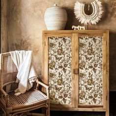 a wooden cabinet sitting next to a wicker chair