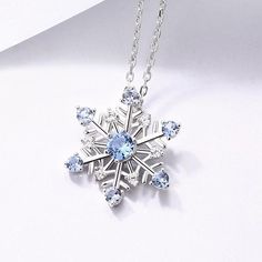 Exquisite Snowflake Pendant Necklace Product Overview Embrace the elegance and sparkle of winter with this exquisitely handcrafted Snowflake Pendant Necklace. Crafted from pure silver, this pendant is designed to captivate with its sophisticated snowflake design adorned with delicate blue stones. Whether you are looking to add a touch of winter wonder to your everyday ensemble or searching for the perfect gift, this necklace is an ideal choice. Key Features Pure Silver Craftsmanship: This pendan Snowflake Gemstone Jewelry, Snow Flake Pendant Necklaces, Silver Cubic Zirconia Snowflake Necklace, Silver Snowflake Necklace With Cubic Zirconia, Christmas Silver Cubic Zirconia Necklace, Sparkling Snowflake Sterling Silver Jewelry, Snowflake Shaped Sparkling Sterling Silver Jewelry, Sterling Silver Snowflake Jewelry For Winter, Sparkling Snowflake Jewelry In Sterling Silver