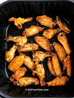 chicken wings cooking on a grill in a pan