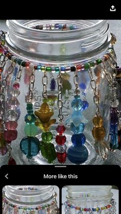 a glass jar filled with lots of different colored beads and chains hanging from it's sides