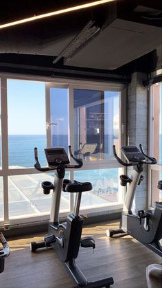 there are many treadmills in the gym by the window overlooking the water and beach