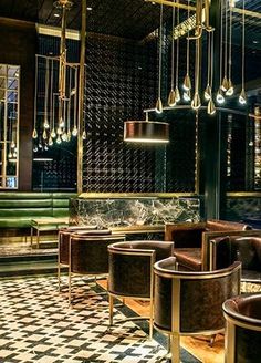 the interior of a restaurant with black and white checkered flooring, chandeliers and chairs