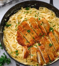 chicken parmesan pasta in a cast iron skillet with parsley on the side