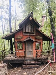 a small wooden house in the woods surrounded by trees