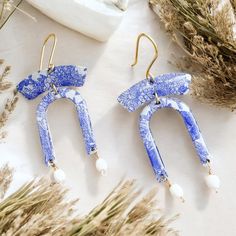 Introducing Lillian, the earrings that capture the essence of a vibrant spirit! With their eye-catching blue hues and delicate finish, they bring a touch of artistry to every look. Elevate your style and let Lillian be your cheerful companion! 💖🎨 The Lillian earrings are handcrafted with a unique combination of materials, including decoupaged brass sealed in resin, accented by glass beads. These earrings are lightweight and comfortable to wear, making them perfect for any occasion. The combination of natural materials and artistic craftsmanship make these earrings a statement piece that can be dressed up or down.  The Lillian earrings feature hand forged brass ear wires. 14K Gold Fill ear wires available for an additional charge for sensitive ears. Geometric Statement Earrings, Blue And White Floral, Style Expert, Blue Hues, Glass Bead, Statement Earrings, Jewelry Earrings Dangle, Etsy Earrings, Glass Beads